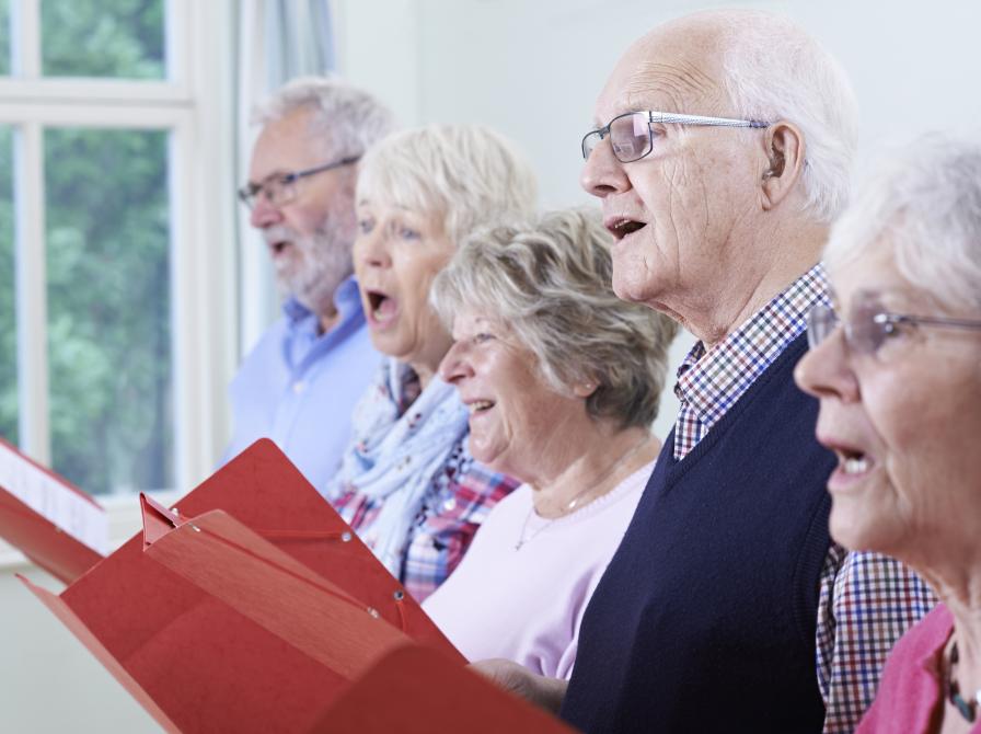 Billedet viser fem syngende mennesker i senioralderen