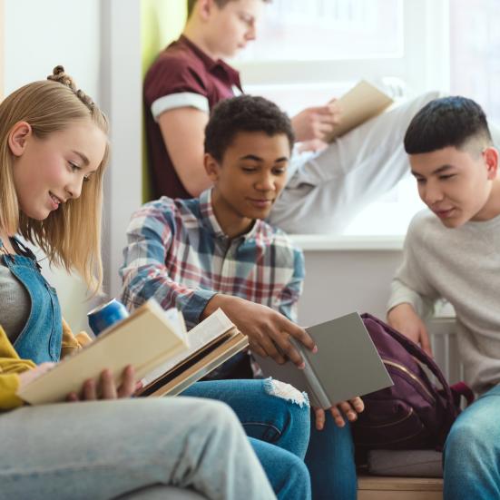 Billedet viser fem teenagere der læser bøger sammen