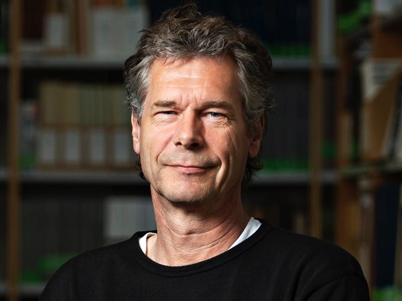 Billedet viser Martijn van Beek foran en bogreol